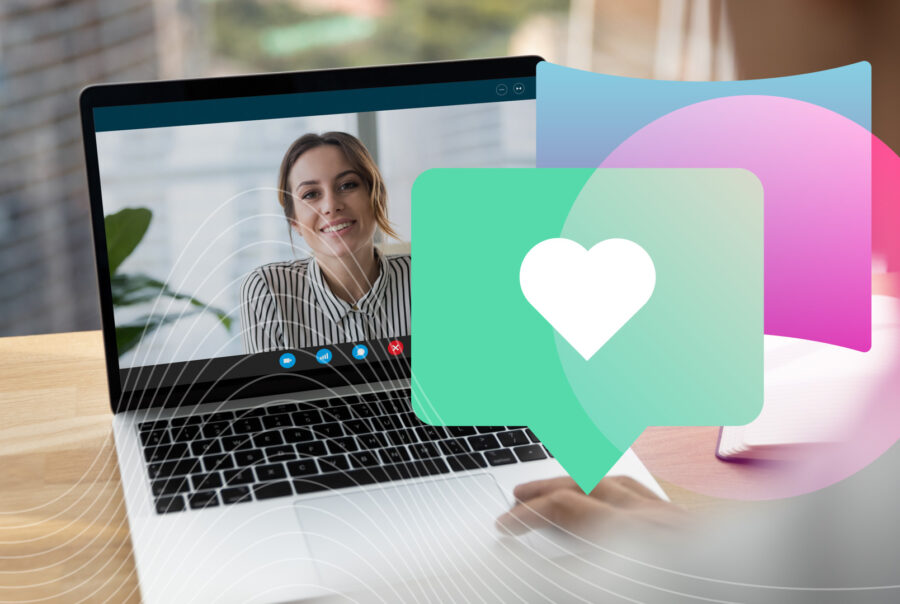 A laptop screen with video conference call shows a woman smiling